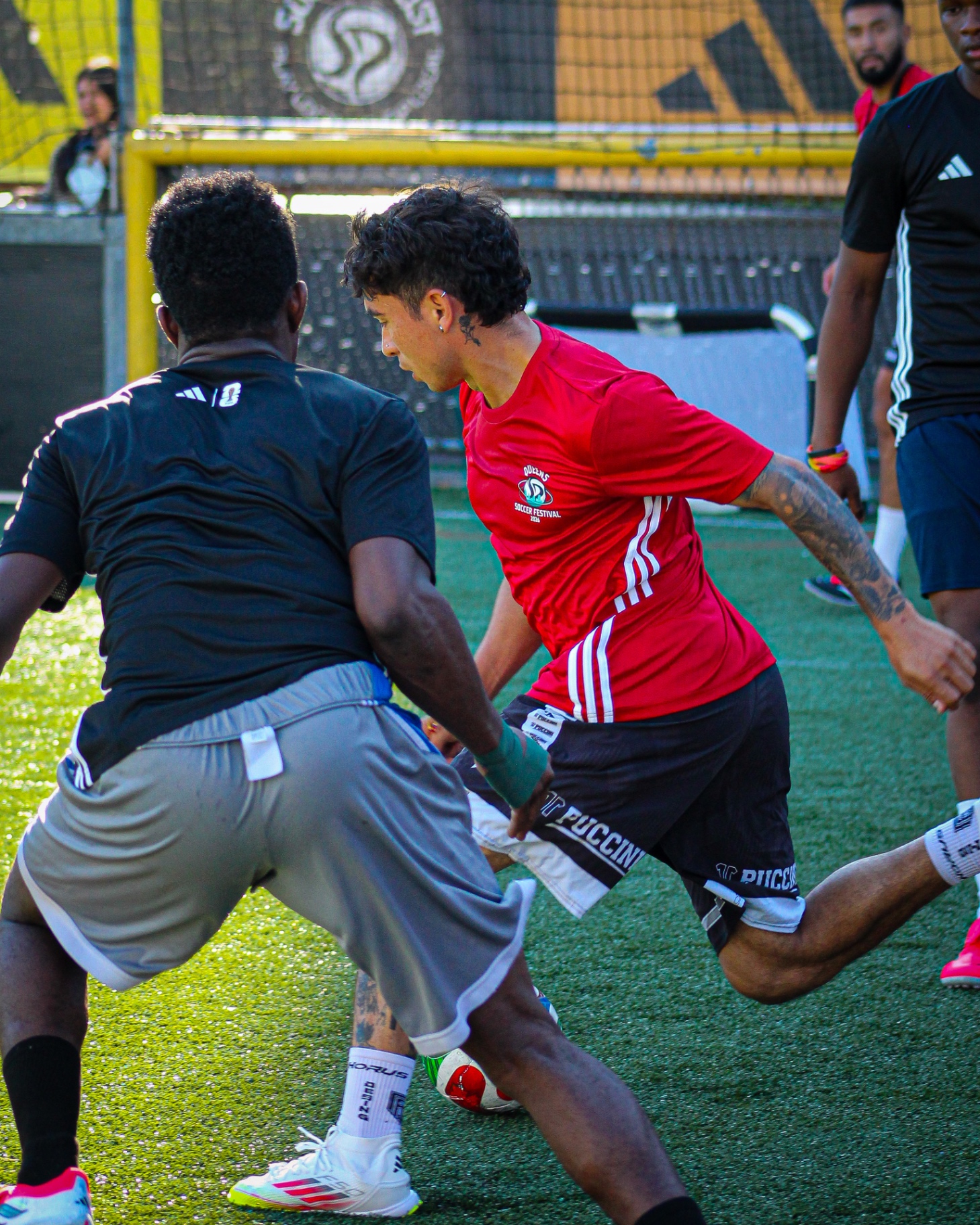 Players battling for the ball at Queens Soccer Festival