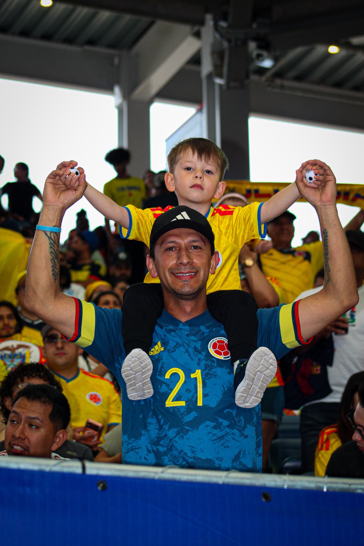 Kid on father's shoulders in the stands