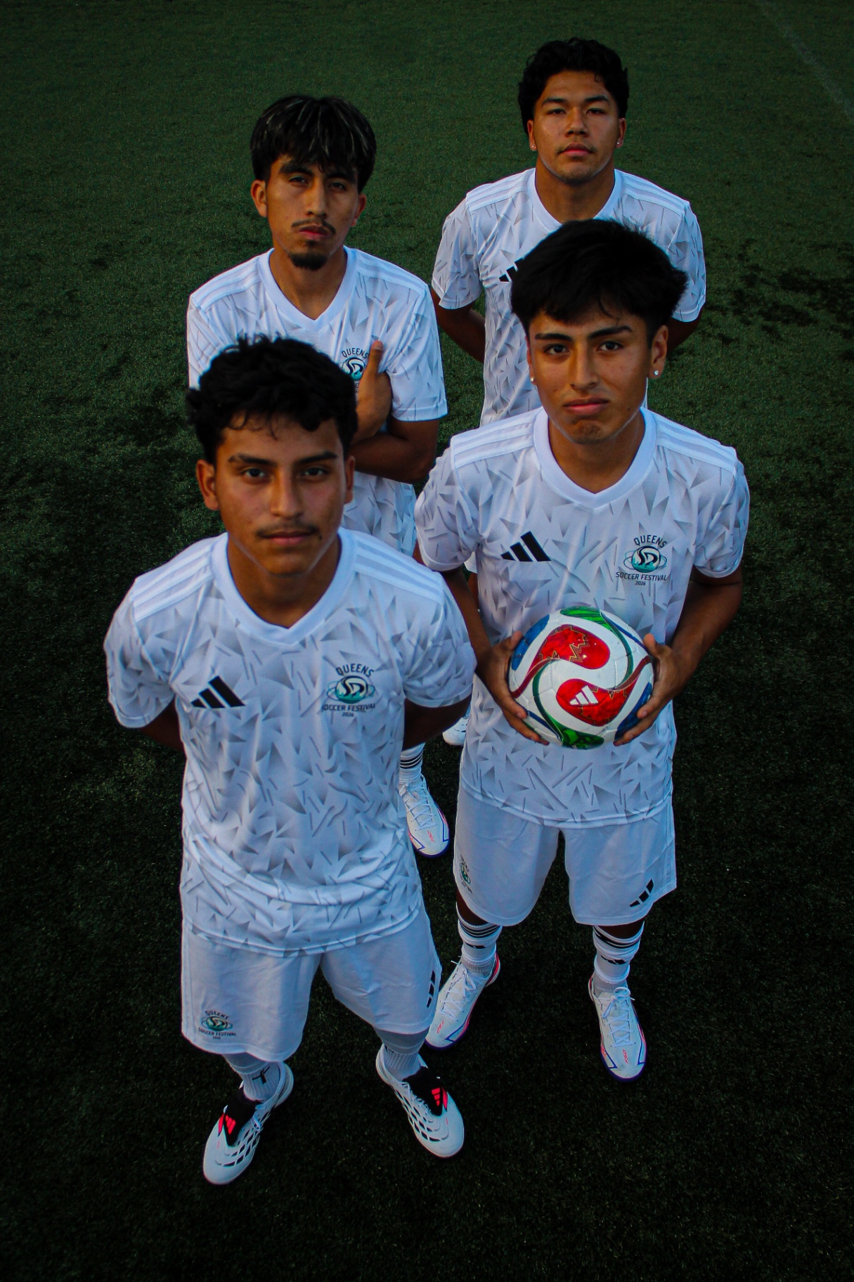 Overhead group portrait of players in white kits at Queens Soccer Festival