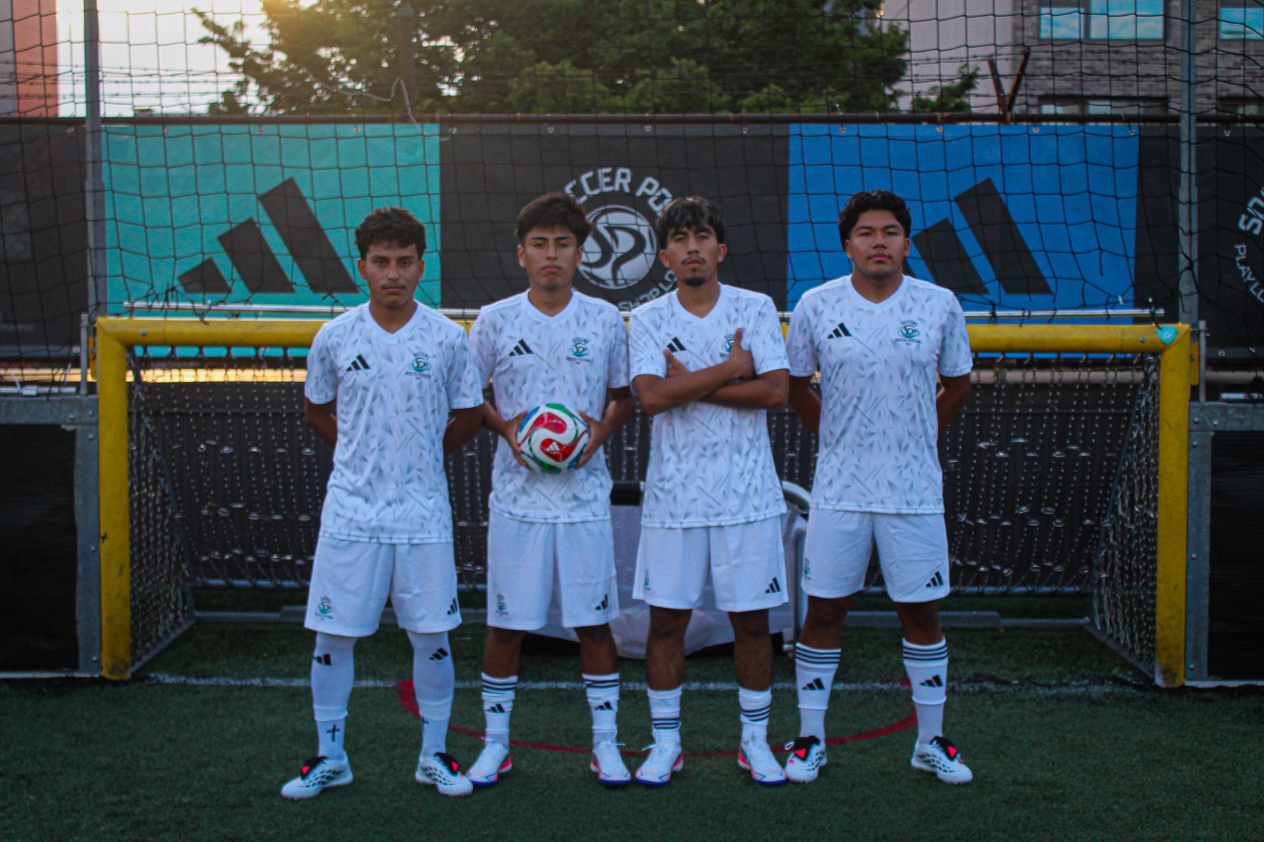 Four players lined up in front of the goal at Queens Soccer Festival